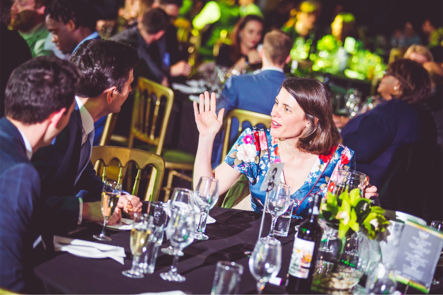 Guest raising a hand at dinner